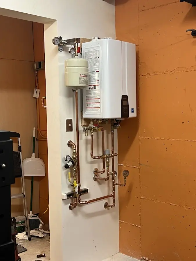 Plumbing technician inspecting water heater connections in Huntingburg